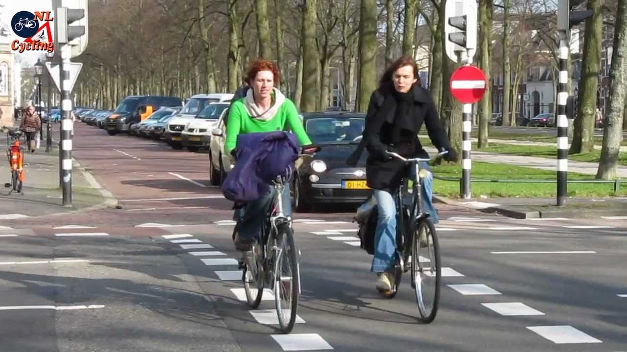 King County Board of Health to Vote on Repeal of Helmet Law Two woman bike without helmets on a street with a bike lane.