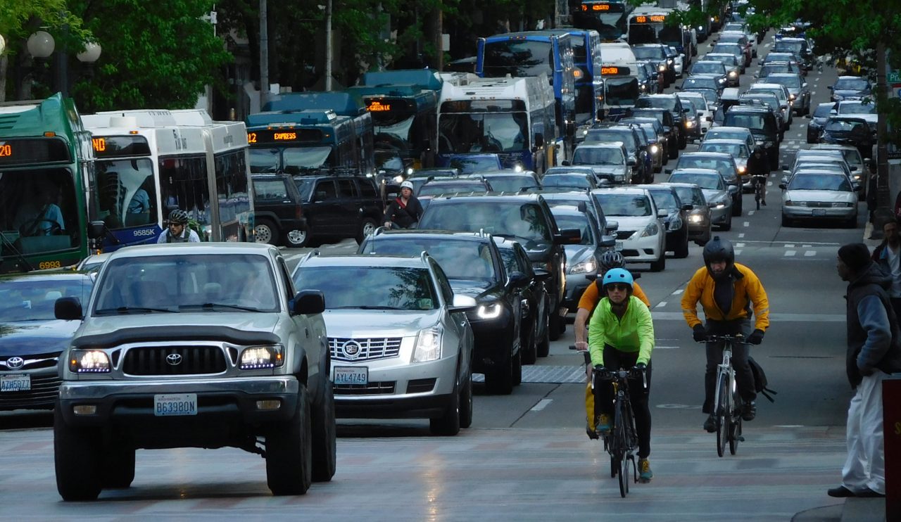 Skip the Ballot, Seattle Should Enact Road Pricing As a Pilot Program A snarl of car traffic on 4th Avenue with transit and people biking on the margins. (Photo by Scott Bonjukian)