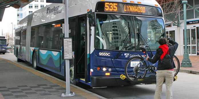 TWITTER_102215_BikesOnST A person loading a bike on a Sound Transit bus, a Route 535 headed to Lynnwood.
