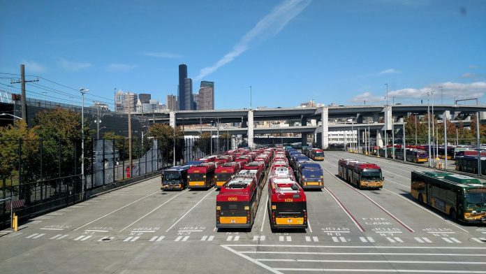 Atlantic Bus Base with Seattle Skyline Rows of buses with the I-90 ramps and Seattle skyscrapers in the background.