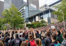 The Urbanist Stands in Support of Black Lives Matter Protesters react with fists raised in solidarity as Nikkita Oliver takes the stage at City Hall on Wednesday June 3rd. (Photo by Doug Trumm)