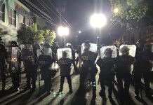 Streetcar and 101 ‘Ghost’ Positions at SPD Survive Budget Deliberations A wall of police with riot shields outside East Precinct.