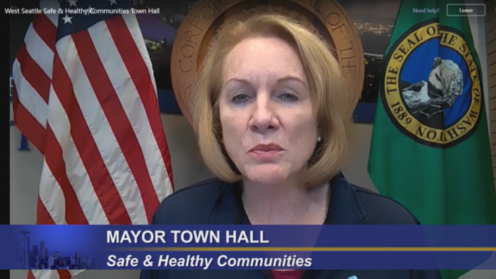 Mayor Durkan at tele-town hall Mayor Durkan flanked by the American flag and Washington state flag.