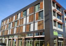 To Address the Climate Crisis We Must Incentivize Passive House Buildings A four story building with wood accents