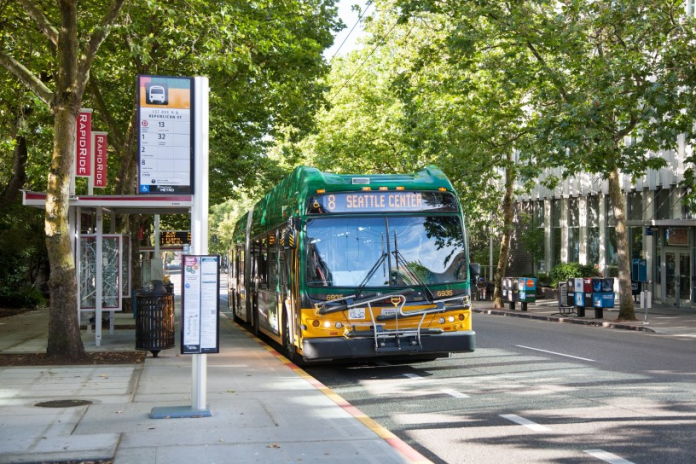 8-bus A photo of a King County Metro bus pulling into a bus station on a tree-lined street.