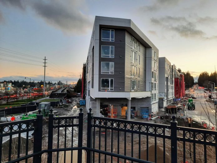 Shoreline apartments from Interurban Trail A new triangular shaped six-story apartment building at dusk.