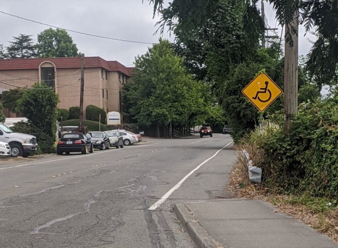 Renton sidewalk by Anna Zivarts A yellow sign with a wheelchair on it indicates the people rolling are to use the gutter after the sidewalk ends. They did paint a stripe along the gutter at least.