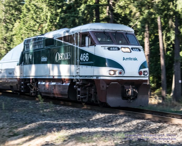 Amtrak Cascades passenger rail A photo of an Amtrak Cascades locomotive car surrounded by forest.
