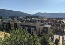 Fast Growing Issaquah Plans for More Density – and Sprawl A grouping of low-rise apartments and townhomes with trees and Issaquah foothills in the background.