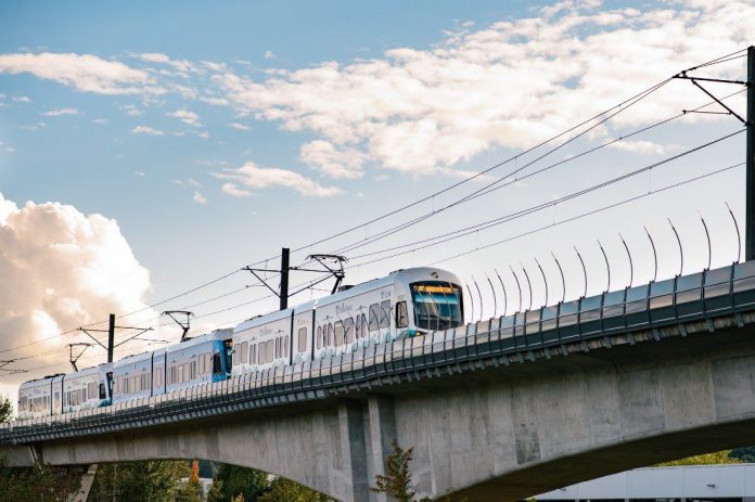 A view of an elevated light rail track with a train approaching.
