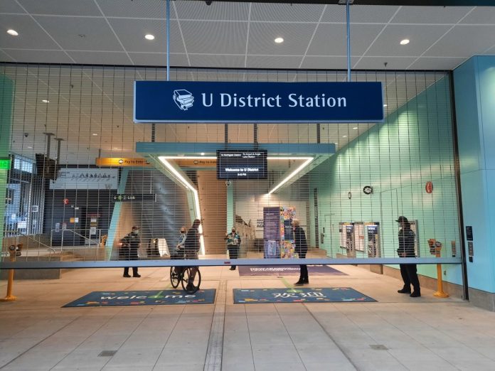 A bicyclist exists the 43rd Street gate of U District Station.