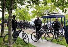 Seattle Police Officers Guild Still Resisting Vaccine Mandate, 32% Haven’t Submitted Proof of Vaccination Three bike-wielding cops form a barricade around a sweep with a large contingent of officers behind