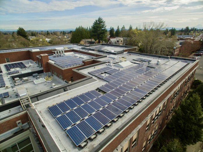 A569DA01-41EB-4E7B-8149-7B99DAE7FE50_1_201_a A photo of a solar array on the rooftop of a school building.