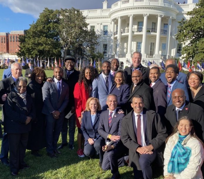 Durkan and co outside of Whitehouse for BIF signing A group of people in business attire pose in from the White House.