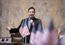 Op-Ed: State Secretary Hobbs Is Wrong to Oppose Ranked Choice Voting Steve Hobbs on the senate floor with American flags in the foreground.