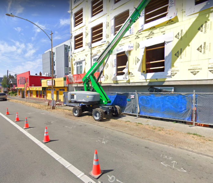Goldfinch Apartments A photo of a green crane in front of an apartment building under construction.