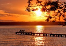 The Urbanist Podcast: Vote Up to the End A view of a sunset over a lake with a pier in it.
