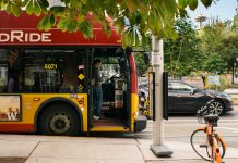 Call to Action: Save the Roosevelt RapidRide A photo of a Rapid Ride bus at stop with a bike parked in front of it.