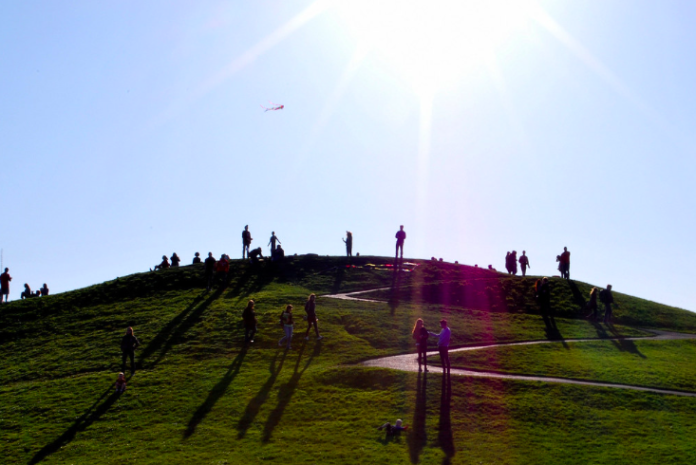 Screen Shot 2022-03-16 at 3.15.43 PM a photo of people standing on a green hill under a blue sky