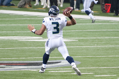 russell wilson A photo of a football player running with the ball.