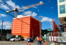 A Housing Advocate’s Guide to Commenting on Seattle’s Comprehensive Plan Update A construction crane over a building under construction with another building under construction across the street and workers standing between them.
