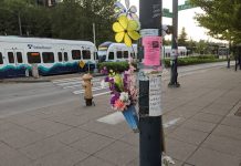 Solving Seattle’s Traffic Death Crisis Demands Citywide Infrastructure Investment The photo is of a heartbreaking memorial of flowers and floral pinwheels left on a light pole by Jennette’s loved ones near where she lost her life. A light rail train is in the background. The sign that’s part of the memorial says “My sister Jennette was hit by 2 cars on June 6. One driver hit and ran. She was a daughter, aunt and mother. We want justice for our family and her son. Forever loved and missed.