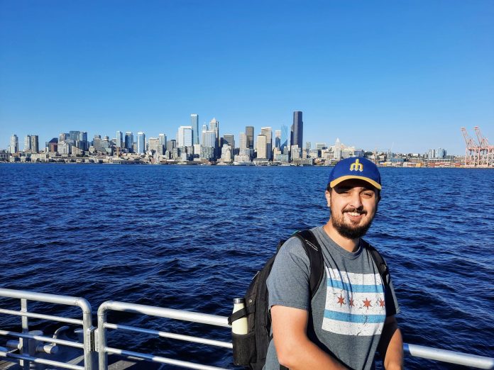 Rian Watt at Seacrest Dock Rian Watt, pictured here with Elliott Bay and the Seattle Skyline. He wears a Mariners hat.