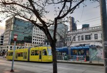 Streetcar Project Could Kickstart Downtown Recovery Two streetcars pass on Jackson Street with the downtown skyline in the background.