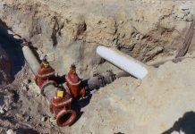 The Urbanist Podcast: How to Crush a Housing Project the Seattle Way Trench cut in dirt with an intersection of iron pipes and a lightly colored stormwater crossing.
