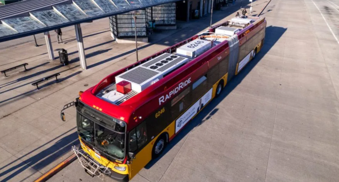 RapidRide H A red and yellow RapidRide bus waits at a stop at an off-street transit center