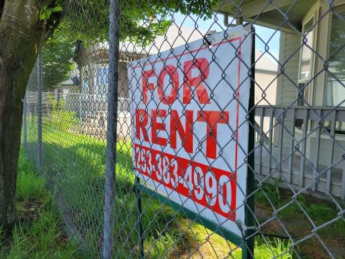 For Rent sign in Tacoma Chainlink fence with a for rent sign for a house.