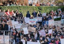 Op-Ed: Seattle Leaders, Keep Your Promise — Keep Cops Out of Schools Students hold signs urging gun prevention and holistic approached to end violence.