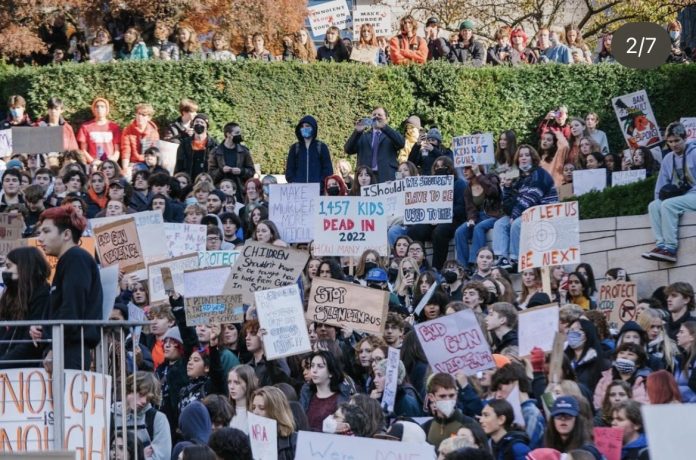 A crowd of students protesting outside Garfield Students hold signs urging gun prevention and holistic approached to end violence.