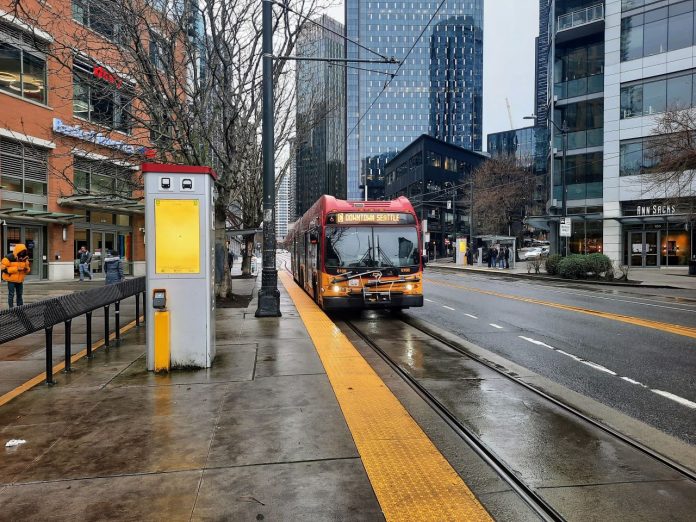 RapidRide C at Westlake and Denny 20230204 Doug Trumm A RapidRIde C bus pulls up to the transit stop in front of Whole Foods at Denny Way intersection on a wet afternoon.