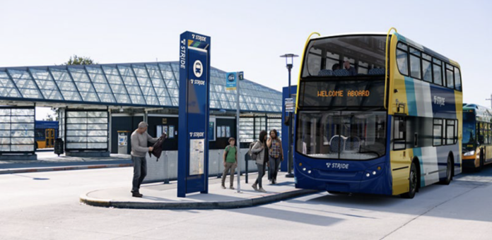 A double decker bus is rendered in Stride livery sitting at a bus station.