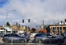 Op-Ed: The Seattle Police Department Has an Efficiency Problem Two police SUVs are parked behind metal barricades blocking traffic from Market Street.