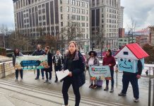 Seattle Social Housing Board Fires CEO, Taps McCoy as Interim Leader Social housing advocates stand on the steps of Seattle City Hall with their house mascot.