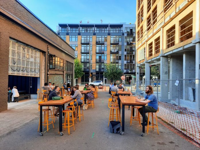 Stoup Patio in Capitol Hill by The Urbanist The back patio at Stoup with Ryan Packer sitting at one of the table and apartment buildings in the background.