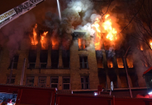 Seattle Aims to Tamp Down Vacant Building Fires Fire and smoke pours out of upper story windows of an old brick building with a fire crane seeking to control them.