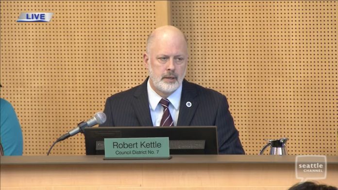 Bob-Kettle-SPOG-Contract-comments-2024-05-14-Seattle-Channel Kattle wears a blue suit and light gray beard and sits on Council dais.