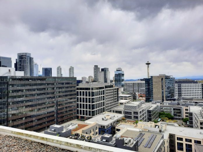 The Space Needle is visible in the distance between towers from a South Lake Union roofdeck.