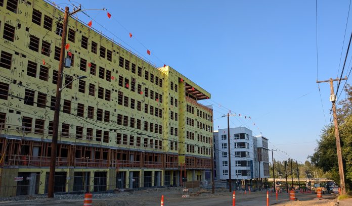 Shoreline TOD An 8 story building under construction near a similarly sized building that is already completed.