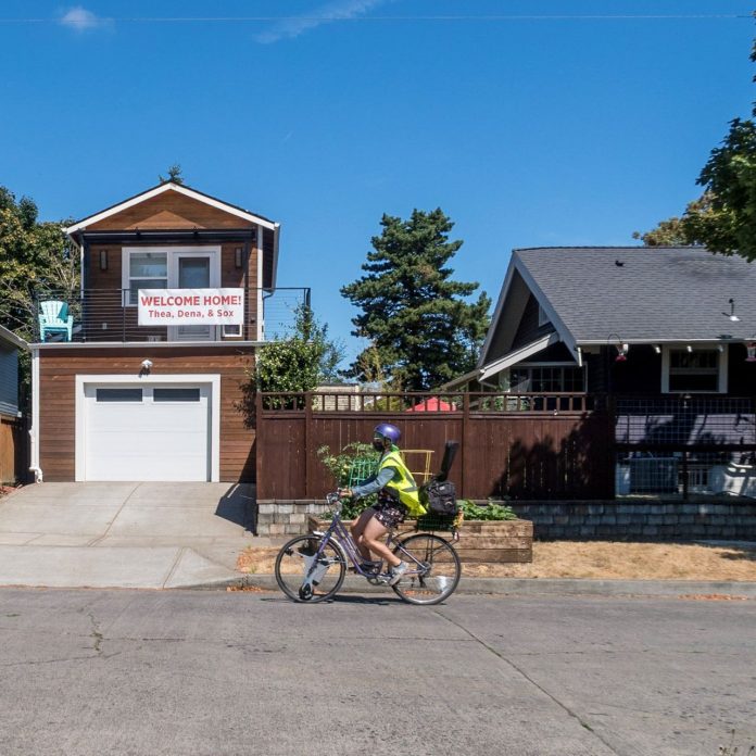 Person biking front of garage ADU - Mark McClure Sightline Library