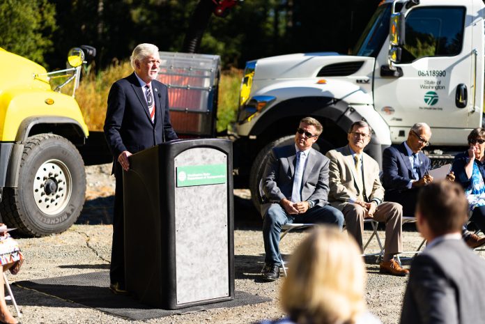 Millar Roger Millar standing at a podium for a photo op