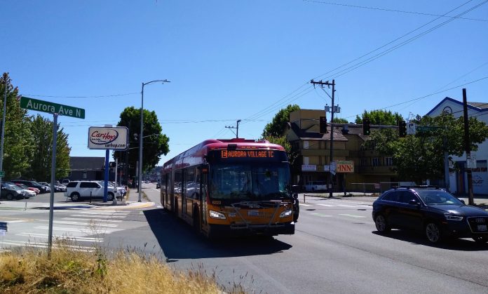 Aurora E Line An E Line bus heads northbound on Aurora Avenue N near Green Lake on a sunny day.
