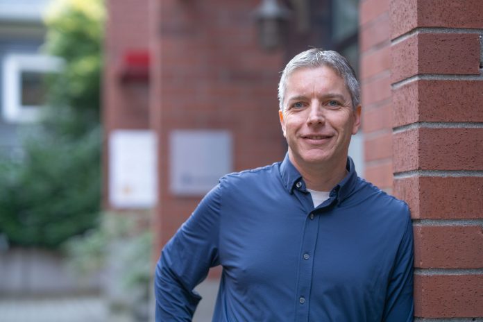 Rory O'Sullivan headshot 3 A middle-aged man stands outside a brick building