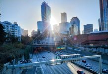 Facing Budget Crisis, Washington’s Leaders Downplay Focus on Highway Expansion Cars use Interstate 5 through Seattle on a sunny day, with the sun just breaking through the city skyline