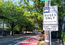 Bellevue Pushes to Open Up Bus-Only Lanes to Private Shuttles A red bus lane in the Rainier Valley with a sign reading "buses only, right turns permitted"