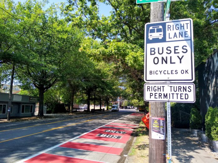 Rainier BAT lane A red bus lane in the Rainier Valley with a sign reading "buses only, right turns permitted"