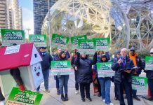Former Seattle Council Candidate Ron Davis Challenges Longtime Legislator Gerry Pollet Ron Davis holds a microphone and a house mascot and a dozen sign wielding advocates standing in front of the glass spheres.